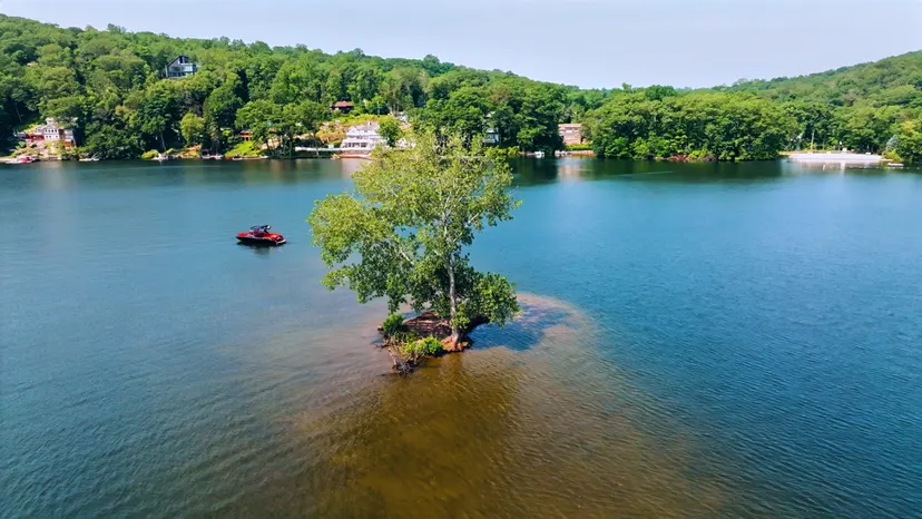 Small wooded island and a personal watercraft on Candlewood Lake in New Fairfield.