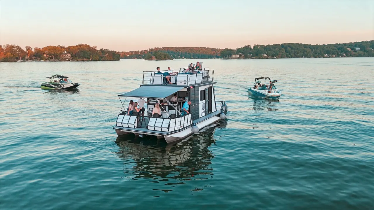 Houseboat with two wake boats on Candlewood Lake.